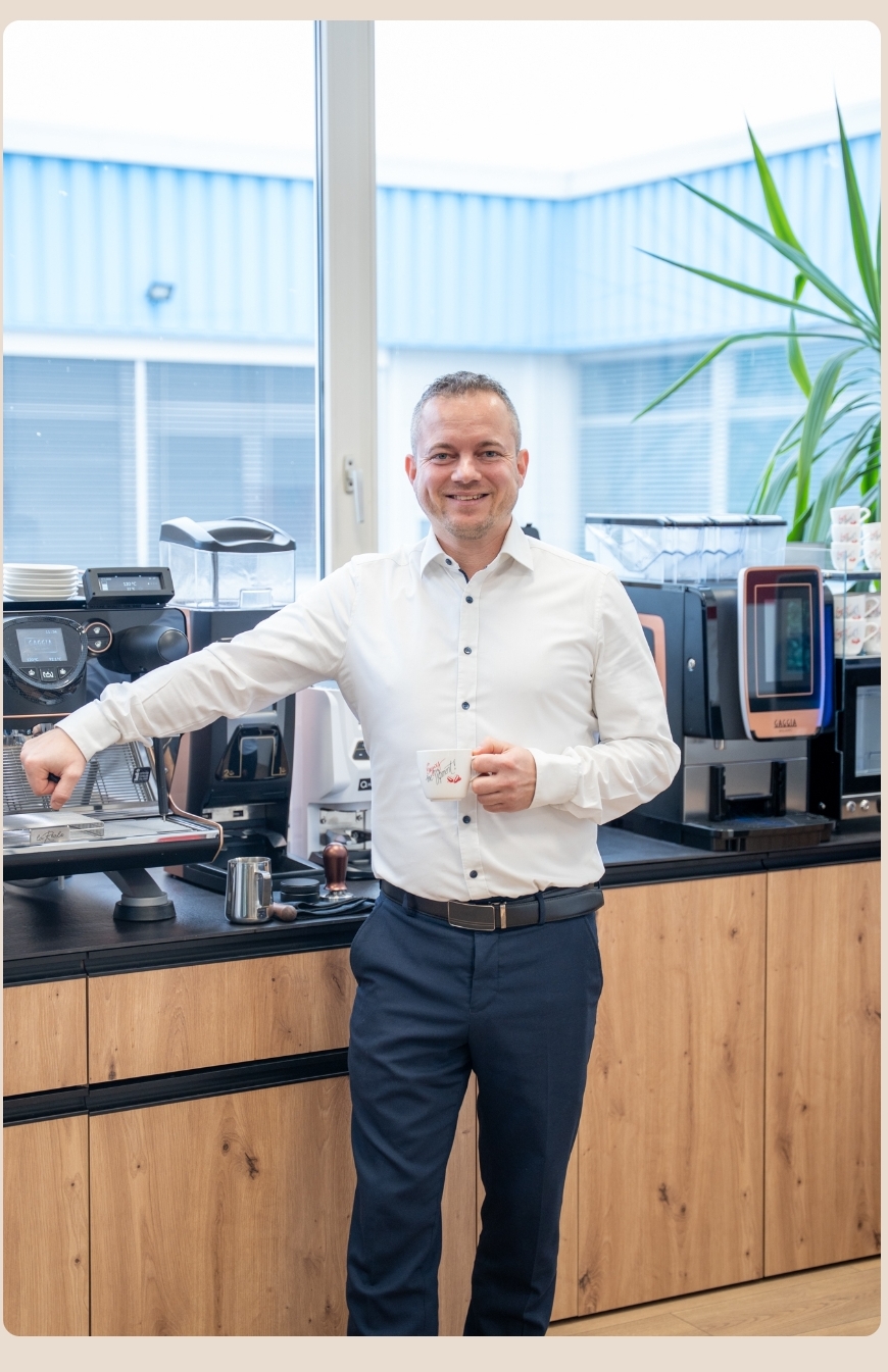 Gernot Handler, Kaffeeberater für Beherbergungsbetriebe, steht vor professionellen Kaffeemaschinen